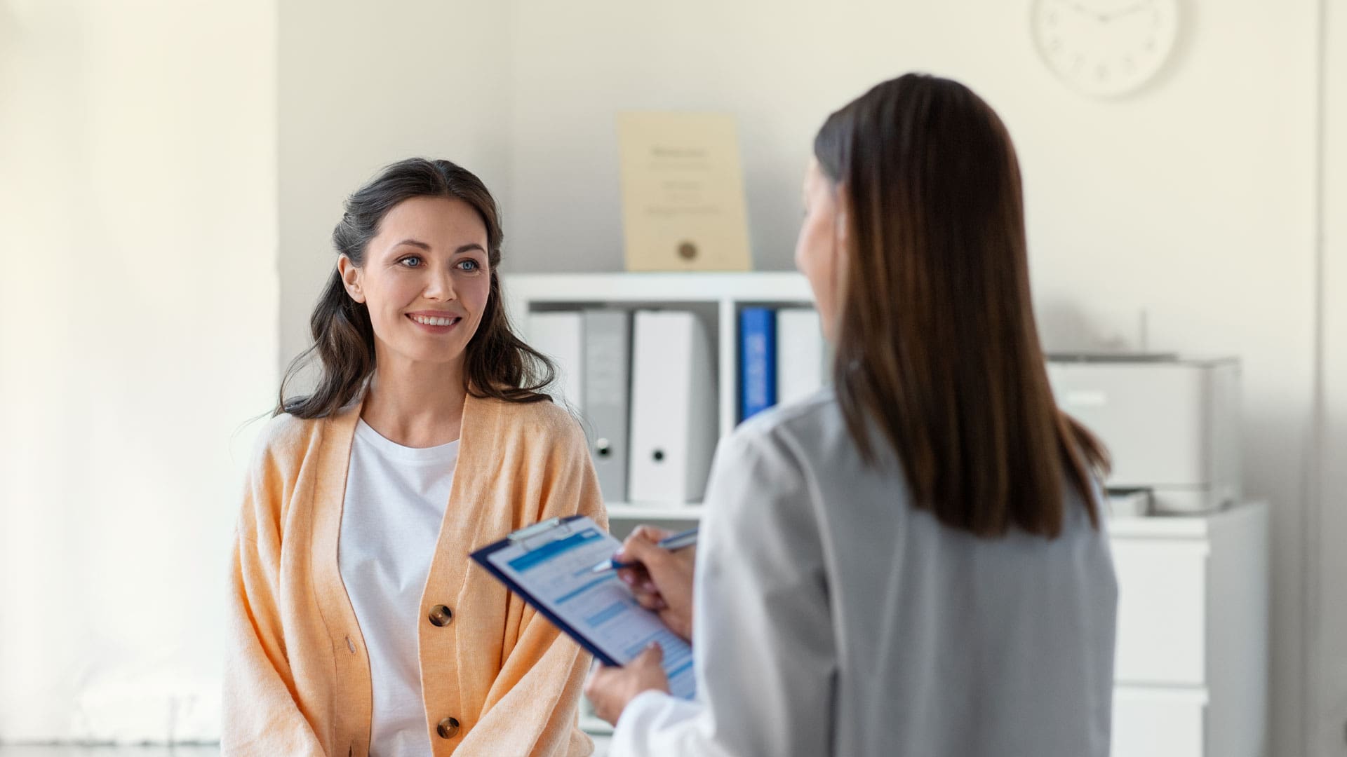 doctor speaking with a female patient and taking notes